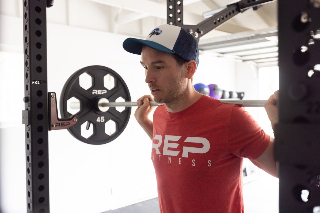 Man doing squats on a power rack